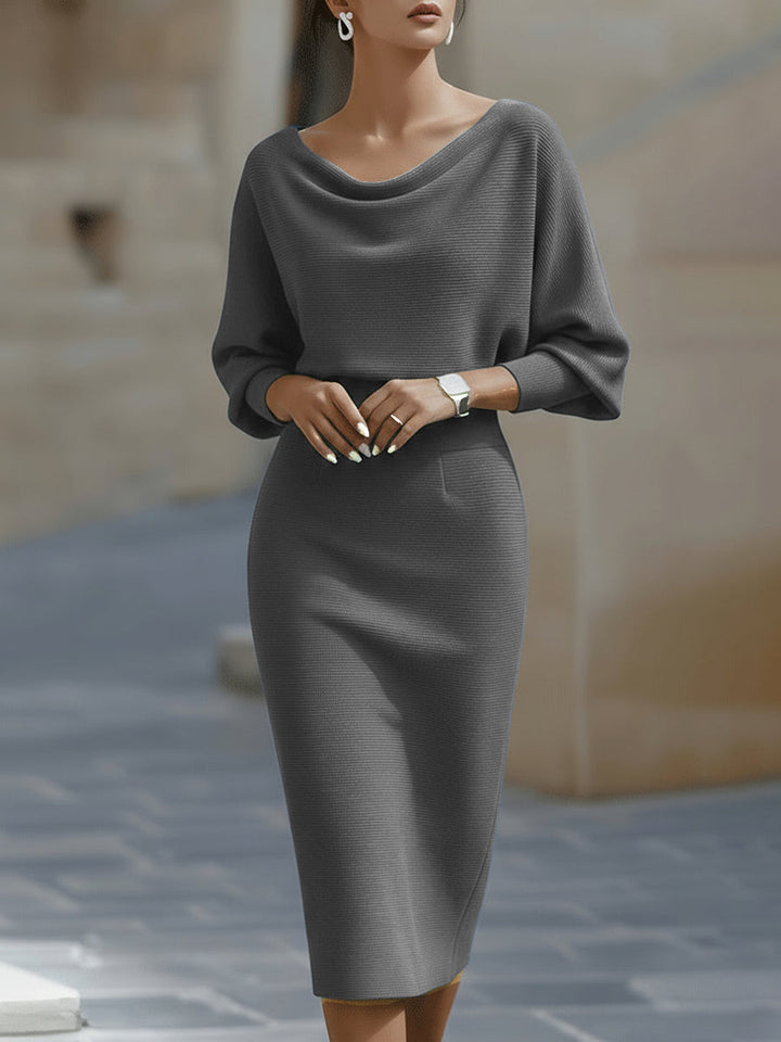 Side profile showing the sculpted bodycon silhouette and midi length of the ribbed knit dress
