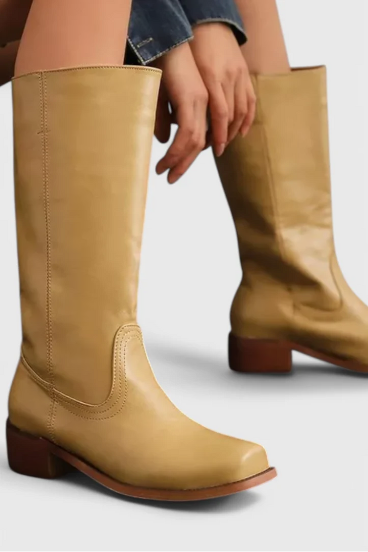 Amelia wearing Classic Knee-High Heeled Boots in yellow with block heel and smooth finish paired with denim