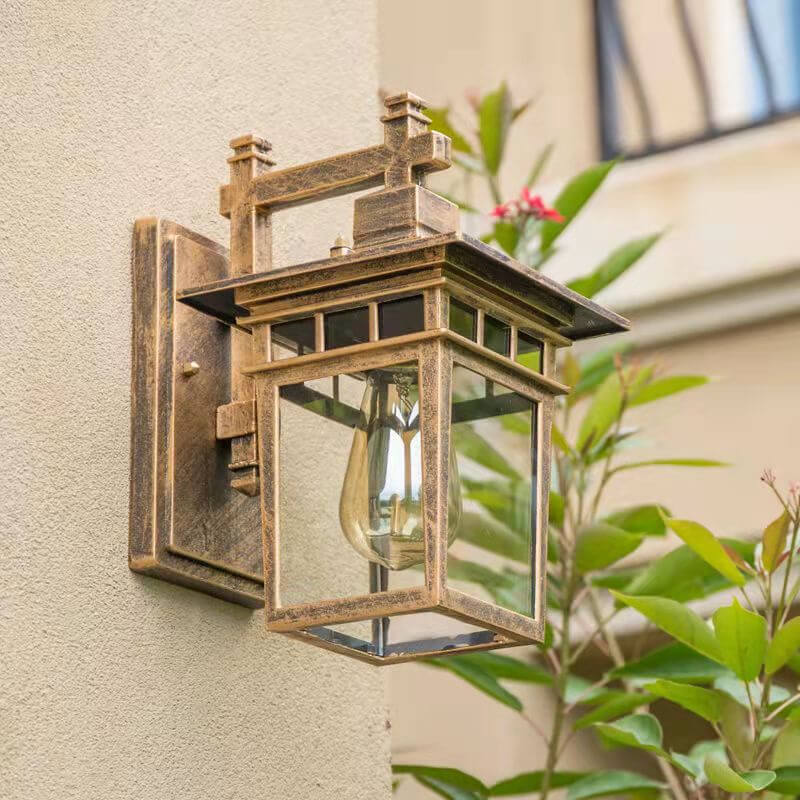 Outdoor waterproof lantern wall light illuminated at dusk with warm glow through clear glass panels