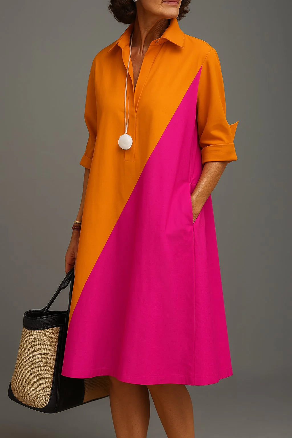 Colourblock midi dress with diagonal orange and fuchsia panels, collared V-neckline, three-quarter sleeves, and relaxed A-line silhouette