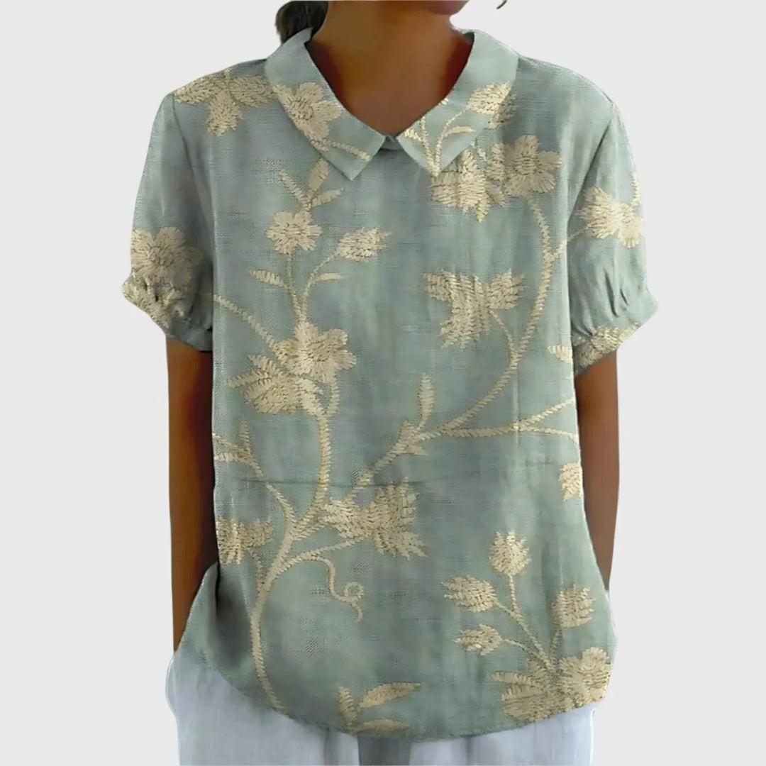Close-up of button-front closure on women's linen floral blouse with Peter Pan collar