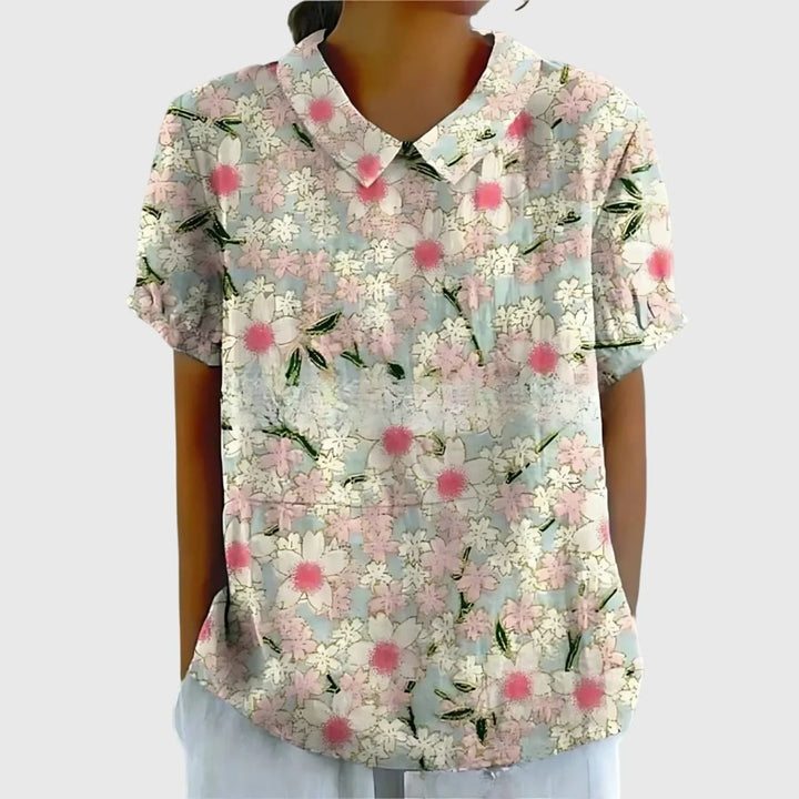 Close-up view of women's linen floral blouse showing climbing flower pattern and short sleeves