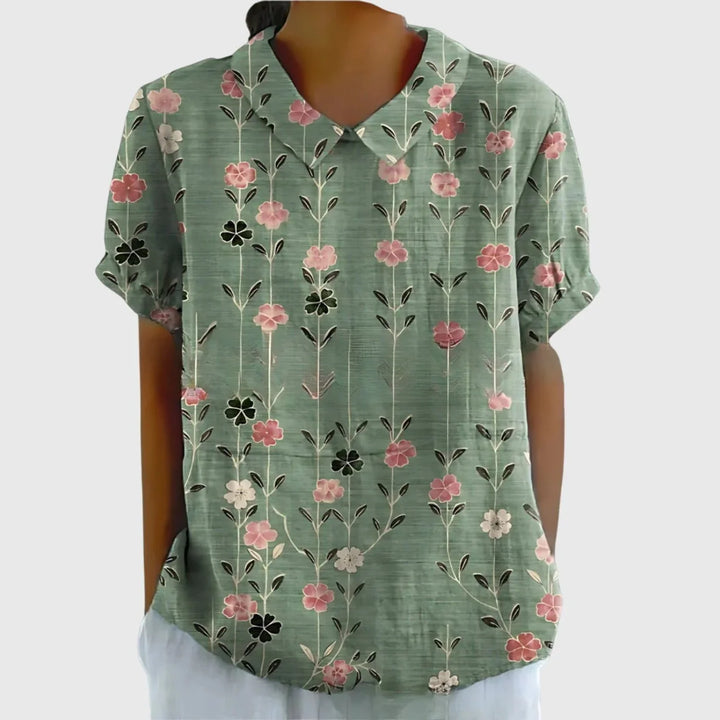 Flat lay of women's linen floral blouse displaying full botanical print pattern