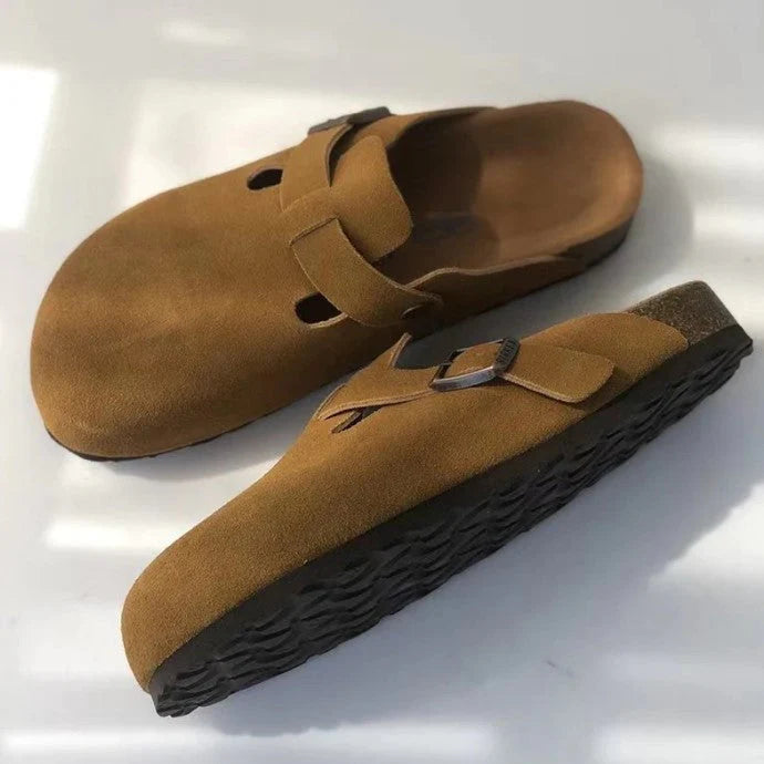 Side view of women's suede clogs with chunky sole and buckle fastening detail