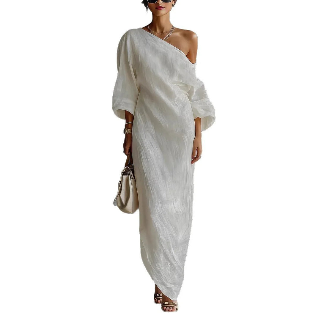 Styling detail of off-shoulder maxi dress with lantern sleeves and minimalist accessories