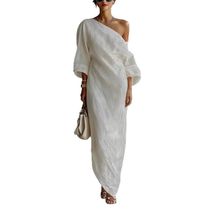 Styling detail of off-shoulder maxi dress with lantern sleeves and minimalist accessories