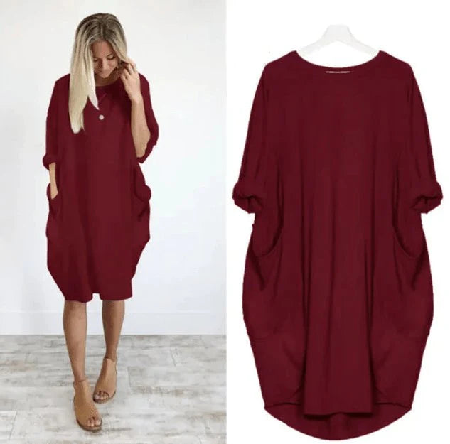 Flat lay of oversized midi dress showing batwing sleeves and round neckline detail