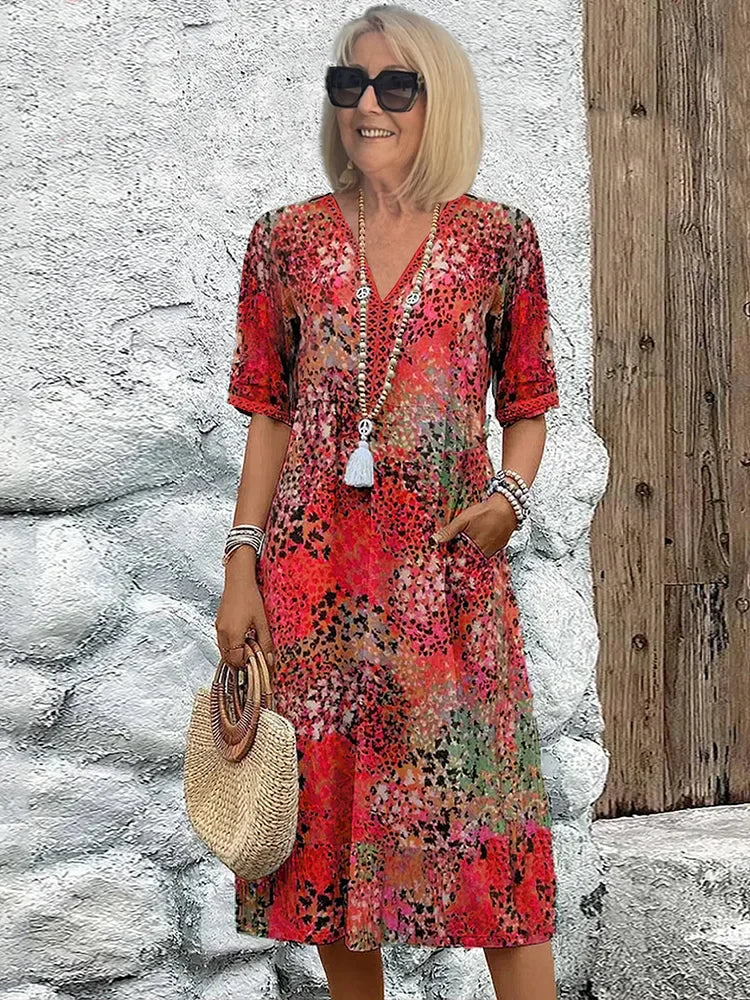 Close-up view of printed midi dress showing V-neckline and elbow-length sleeves with abstract floral pattern