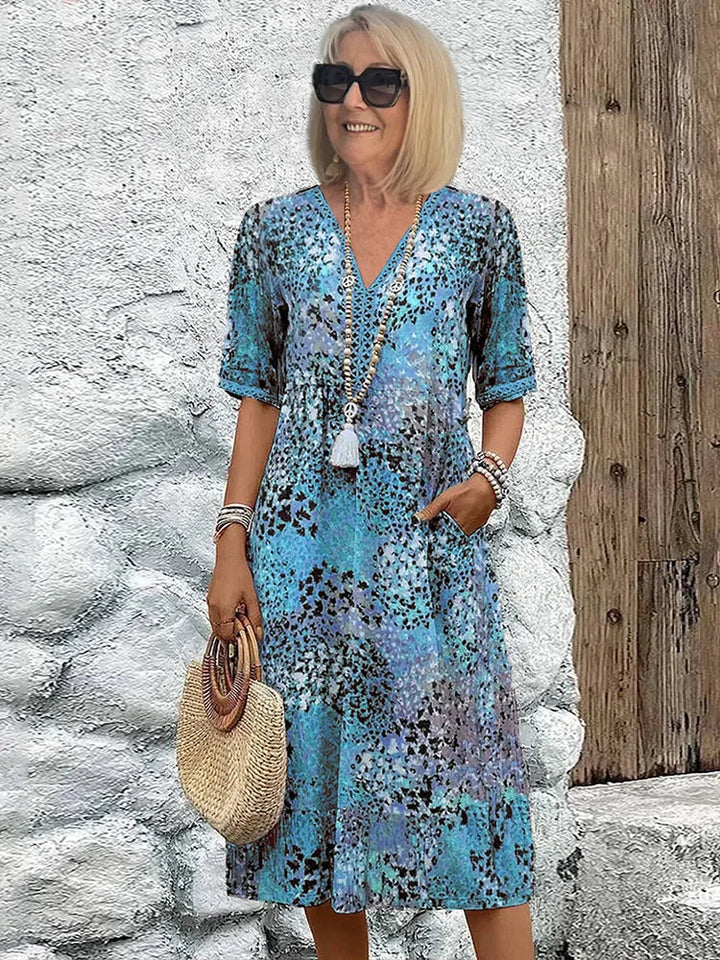 Side view of flowing printed midi dress with relaxed silhouette and side pockets