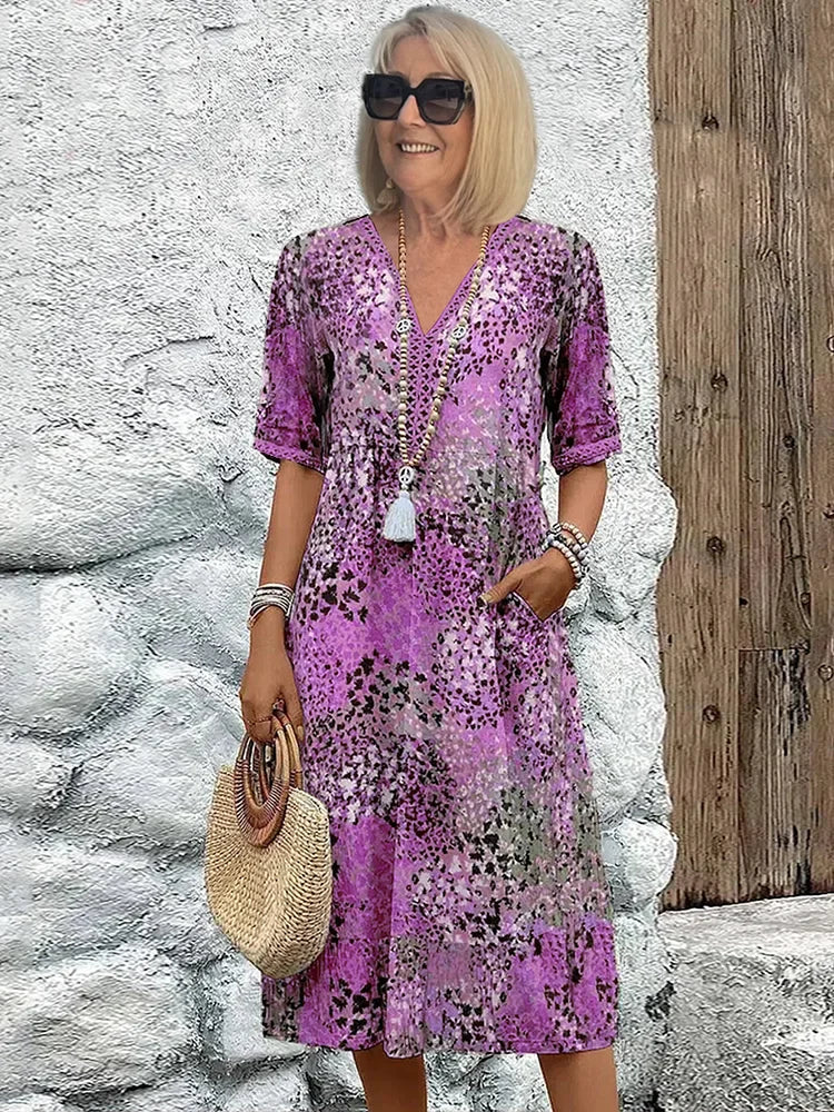 Woman styling printed V-neck midi dress with woven bag and sandals for casual summer look