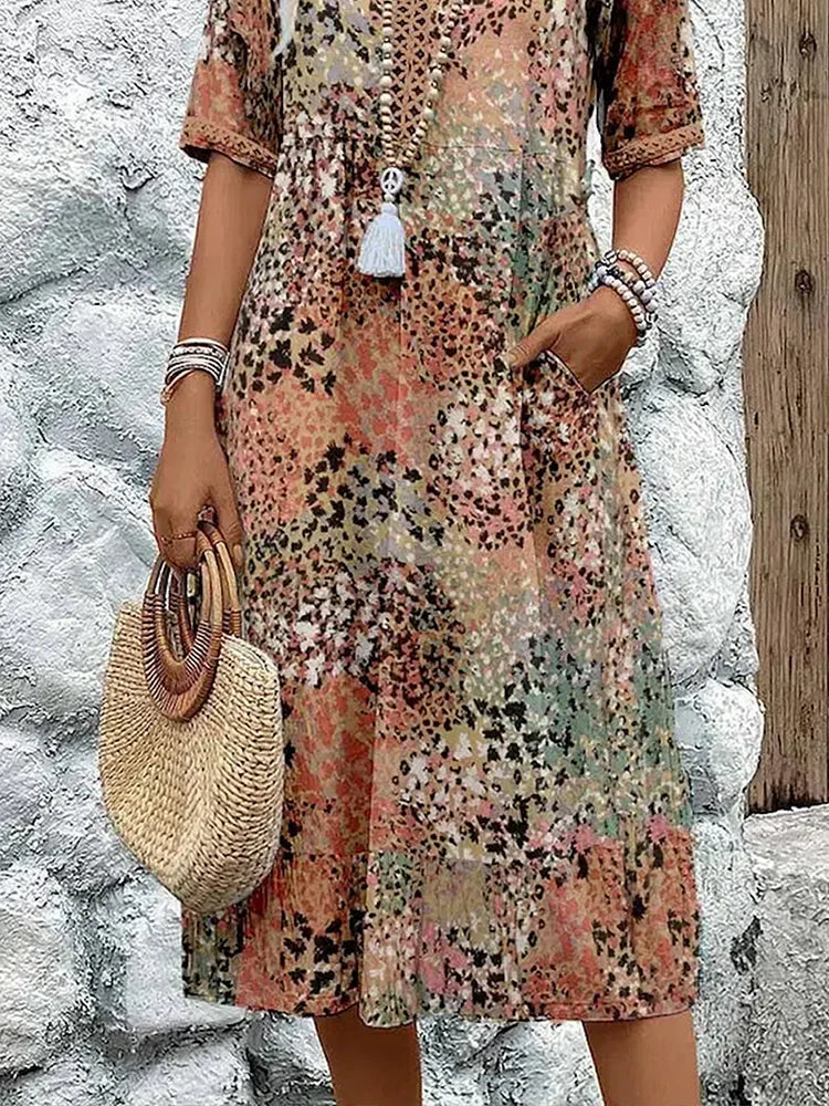 Lifestyle shot of woman in printed V-neck midi dress styled for relaxed summer occasion