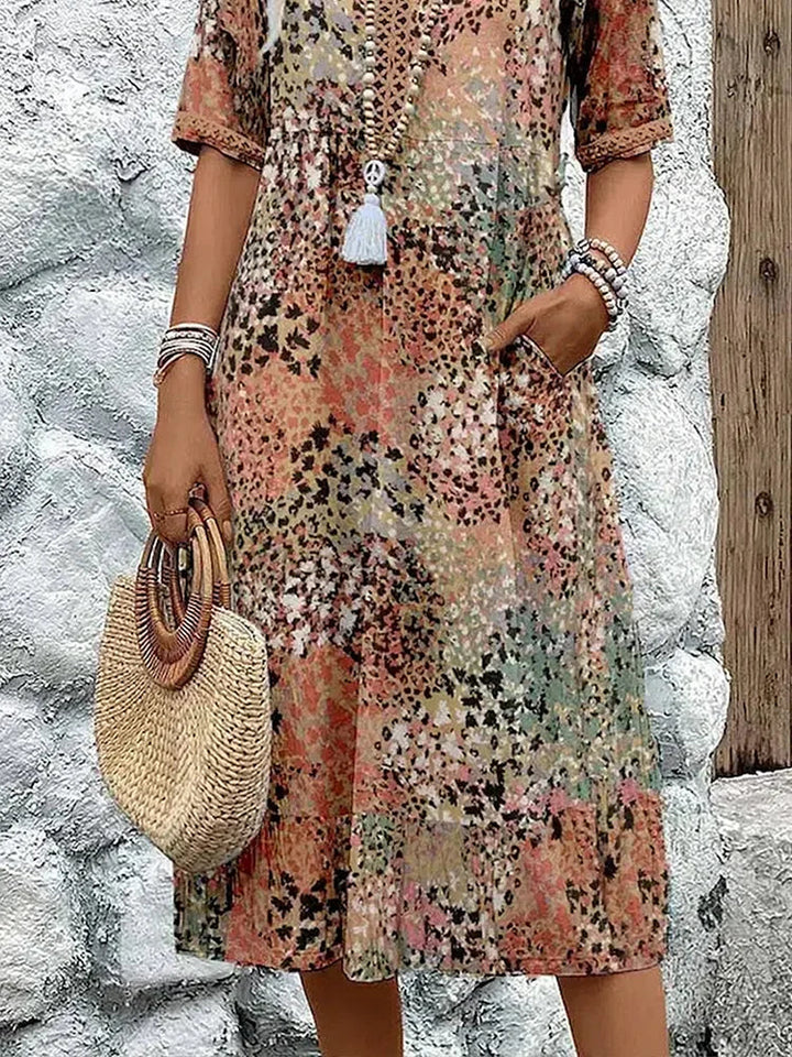 Lifestyle shot of woman in printed V-neck midi dress styled for relaxed summer occasion