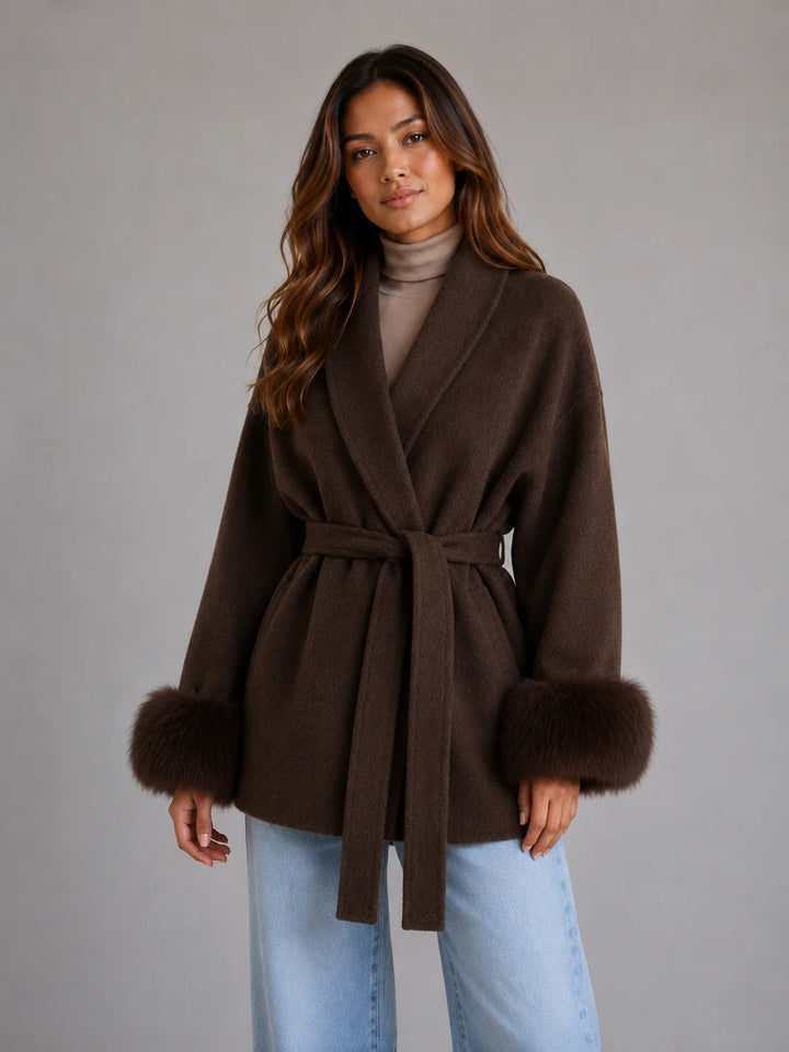 Belted coat with faux fur cuffs styled over turtleneck and jeans for casual elegance