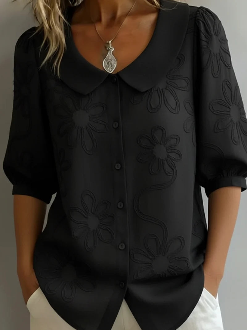 Women's embroidered blouse styled with white trousers for casual daywear