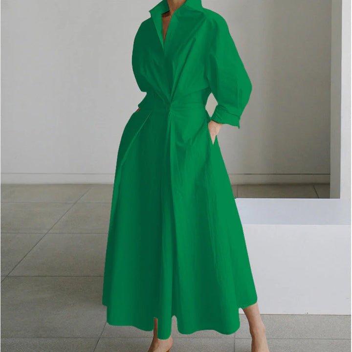 Side angle of newspaper print maxi dress displaying flowing full-length silhouette and tie waist