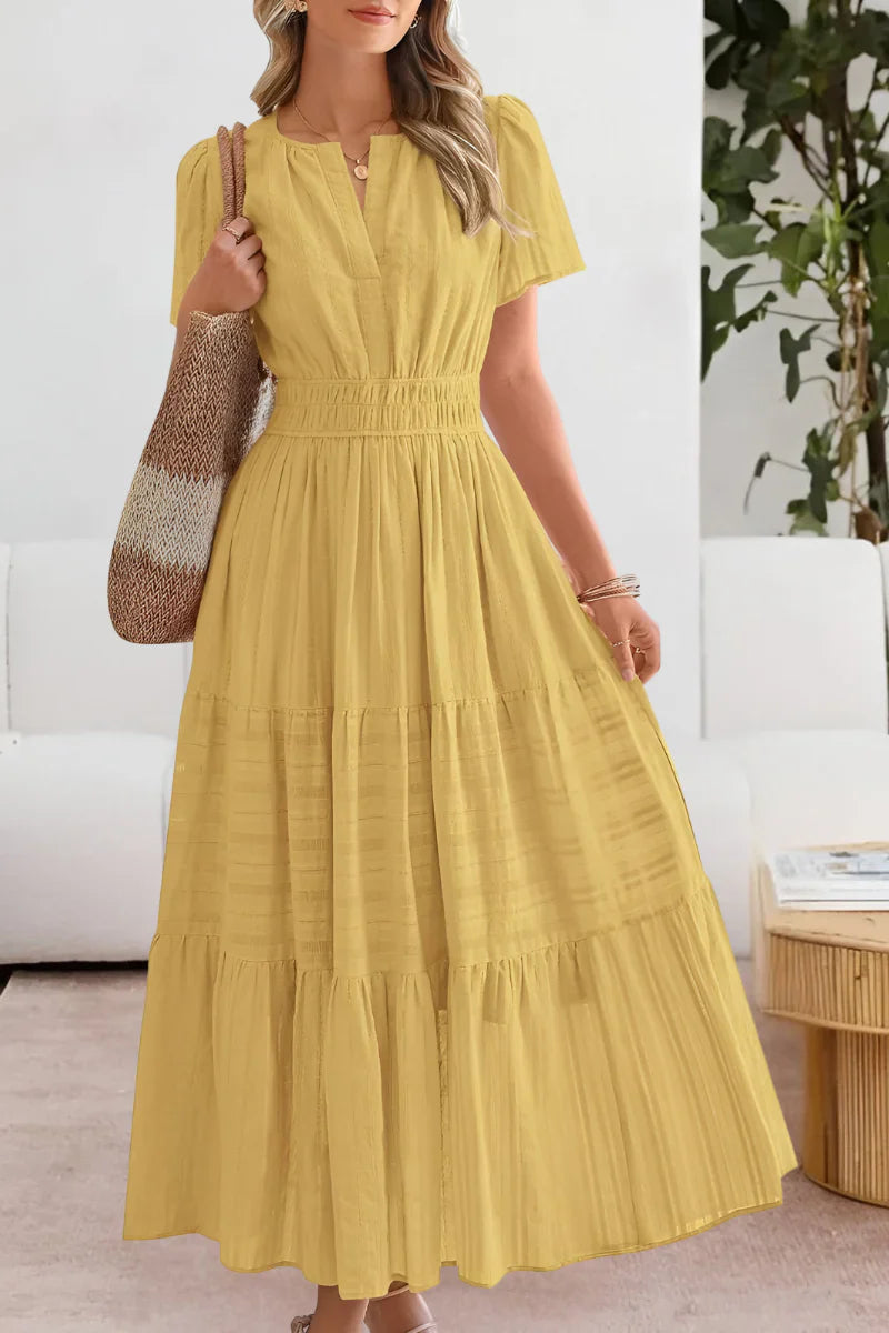 Tiered midi dress in soft yellow with notch neckline and elasticated waist, styled with woven bag