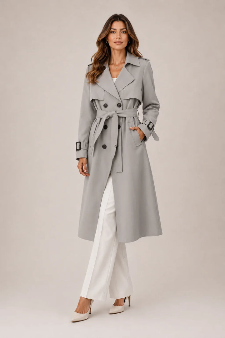 Side view of long tailored trench coat showing streamlined silhouette and structured fabric