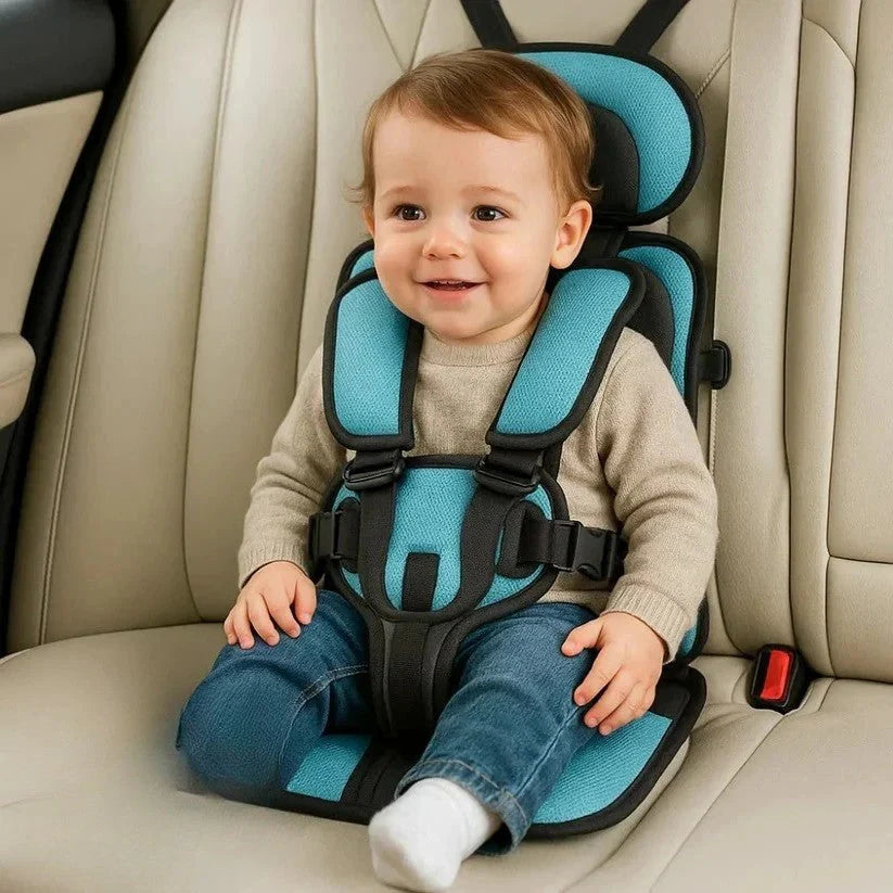Toddler secured in portable travel car seat with five-point harness and padded blue cushioning in vehicle interior