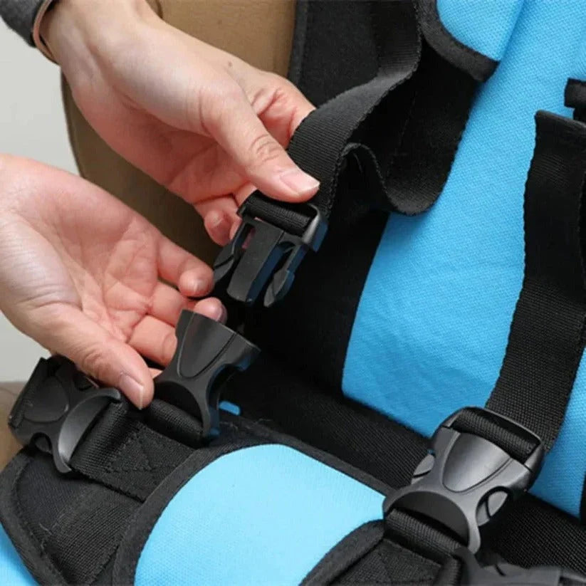 Compact child travel seat with blue cushioning and black harness straps fitting easily into bags for holiday transport