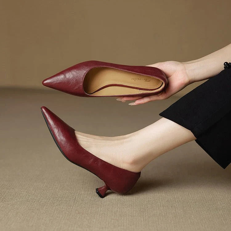 Close-up of pointed-toe leather heels showing smooth burgundy leather upper and artisan-crafted construction