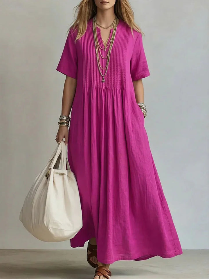Woman wearing magenta Elegant Pleated Dress with pintuck bodice and flowing maxi length for summer occasions