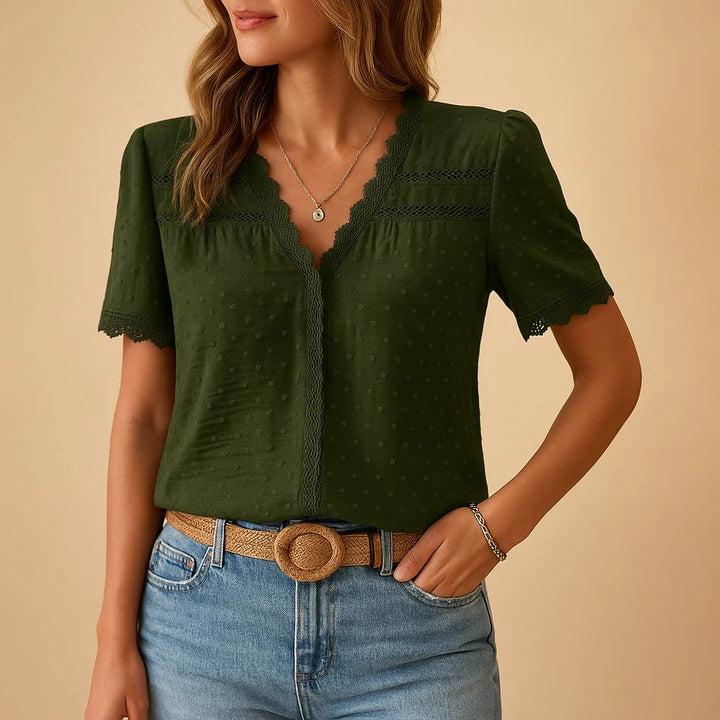Close-up view of delicate lace detailing on v-neckline of women's textured blouse