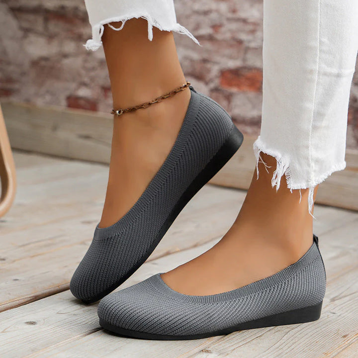 Side profile of women's ribbed knit flats with rounded toe and supportive footbed
