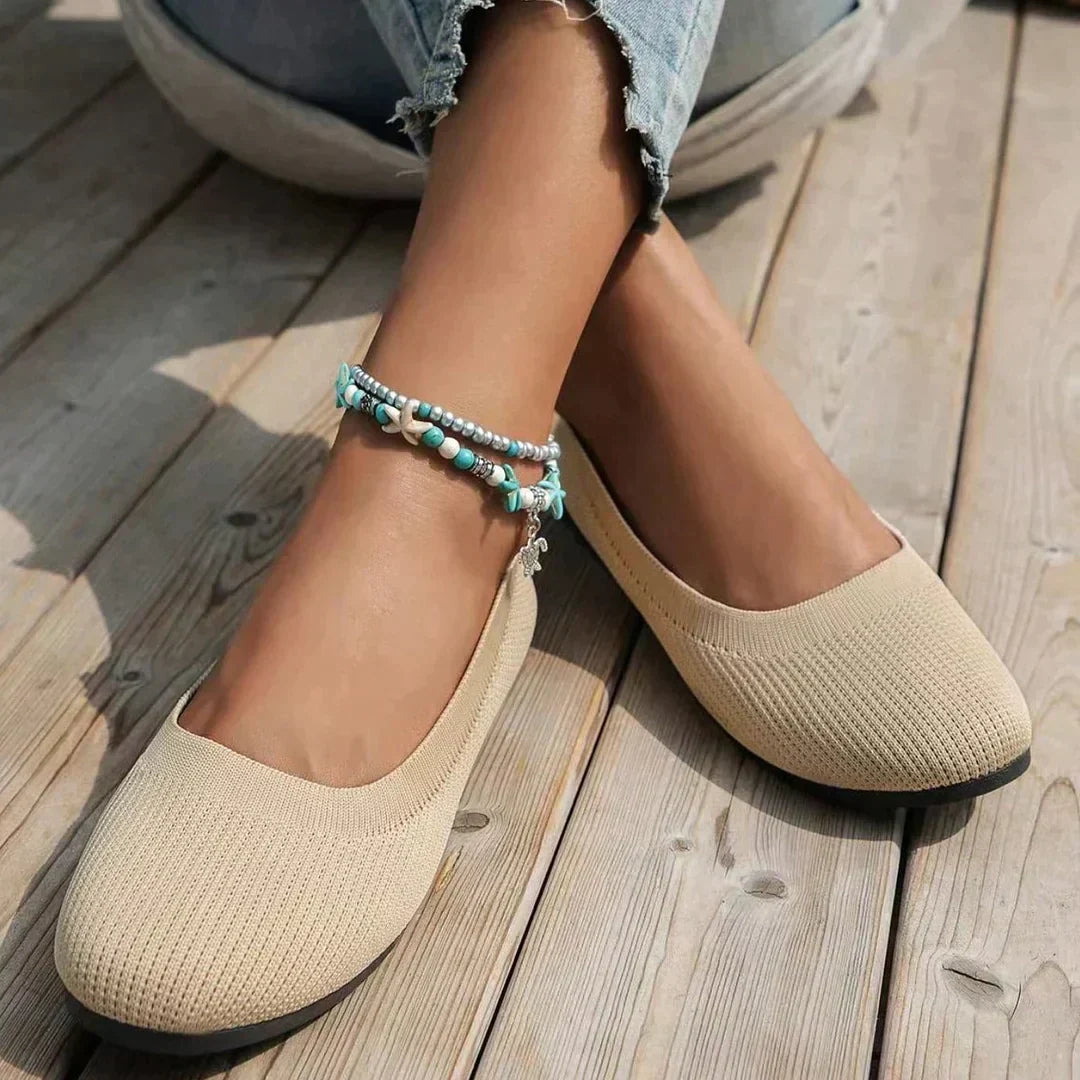 Women's knit flats in grey worn casually showing comfortable slip-on design and grip sole