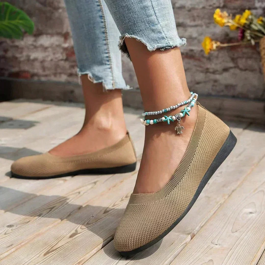 Women's grey ribbed knit flats on wooden deck showing all-day wear design and traction sole