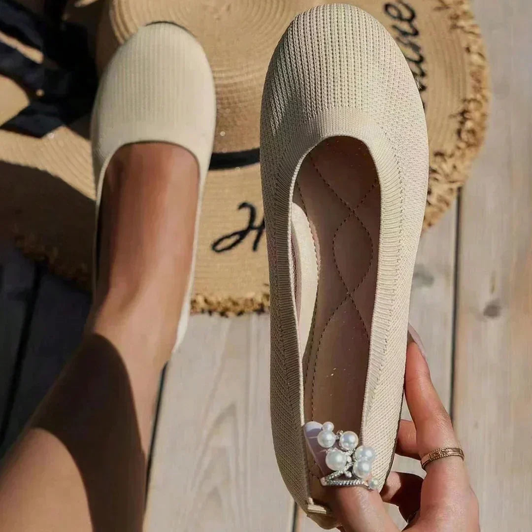 Side angle of women's slip-on flats displaying cushioned insole and structured knit upper