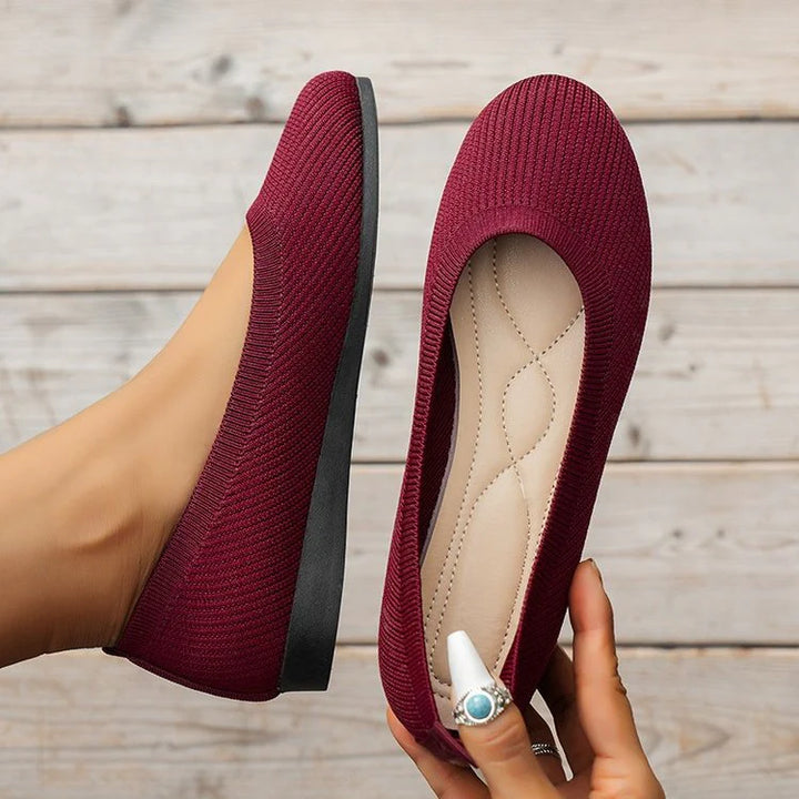 Detail shot of women's knit slip-on flats showing breathable textile upper and supportive design
