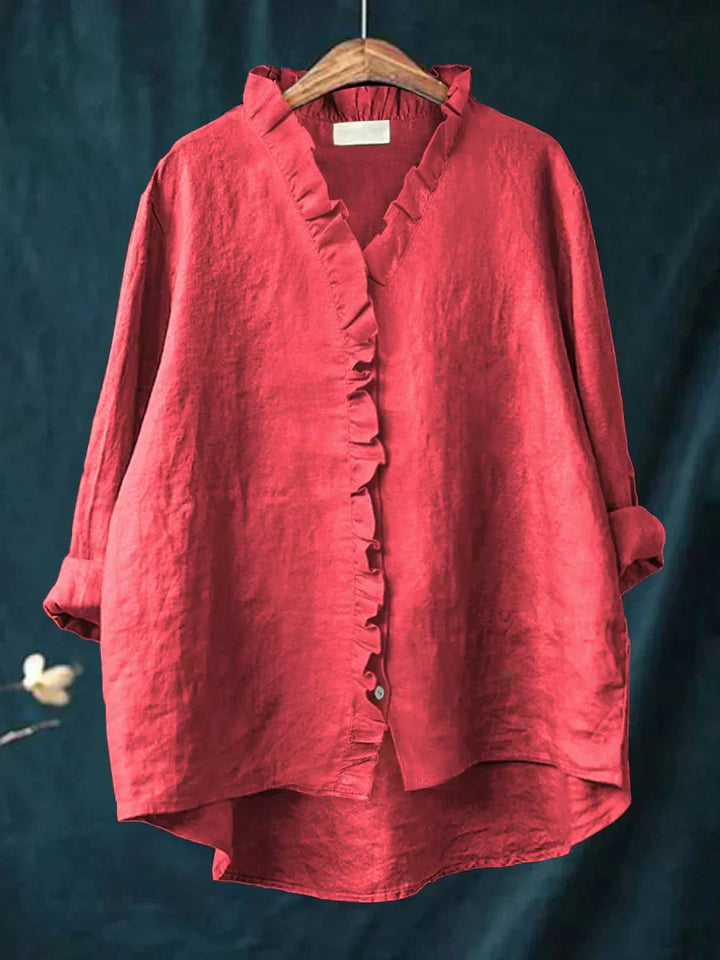 Women's ruffle v-neck blouse in coral red with button-front closure and three-quarter sleeves displayed on hanger