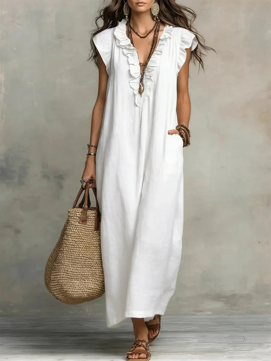 Full-length view of ruffle maxi dress styled with flat sandals and woven bag