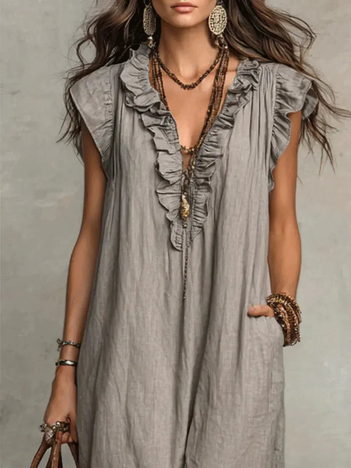 Model wearing grey ruffle maxi dress with layered jewellery and casual accessories