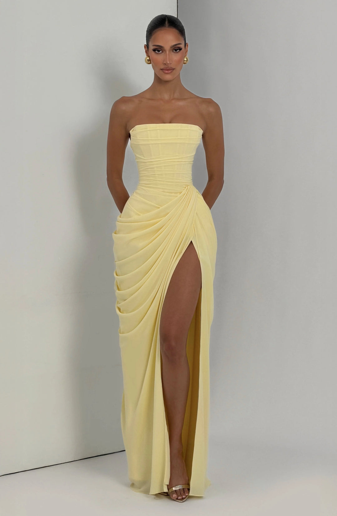 Strapless maxi dress in motion showing leg split and draped waist design