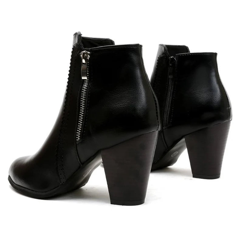 Close-up of chunky block heel and metal zip detail on women's ankle booties