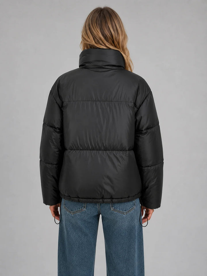 Front view of cropped puffer jacket with high stand collar and full zip fastening for women