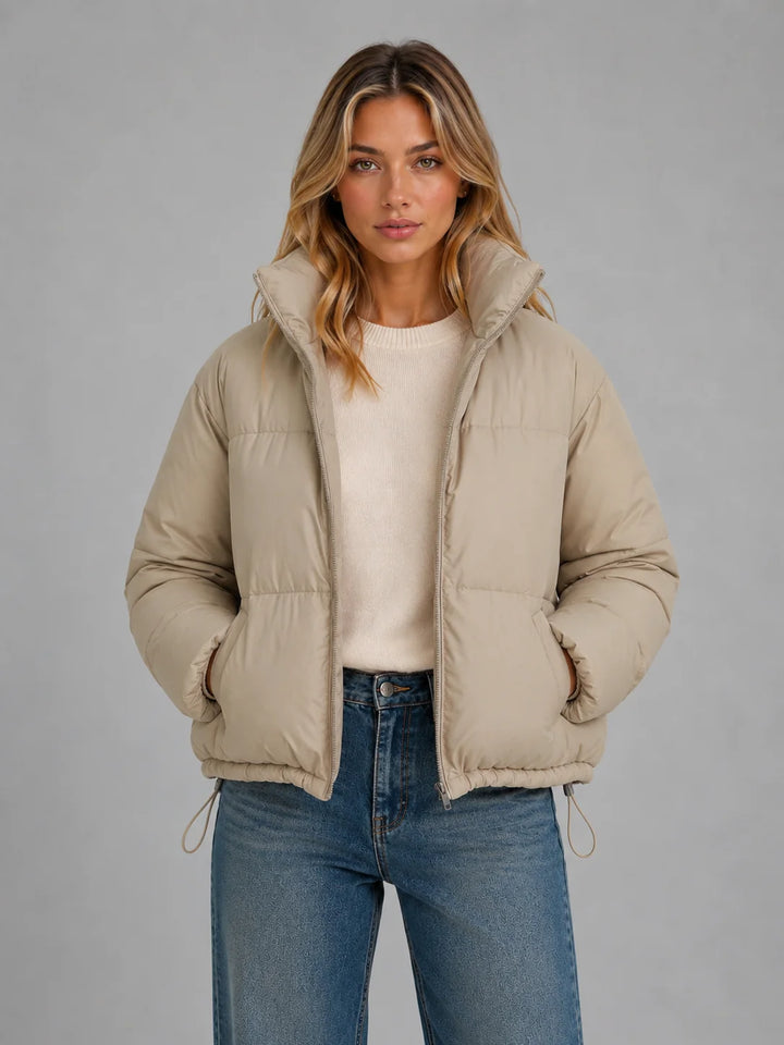 Close-up of high neck quilted coat with adjustable drawcord hem and lightweight padded construction