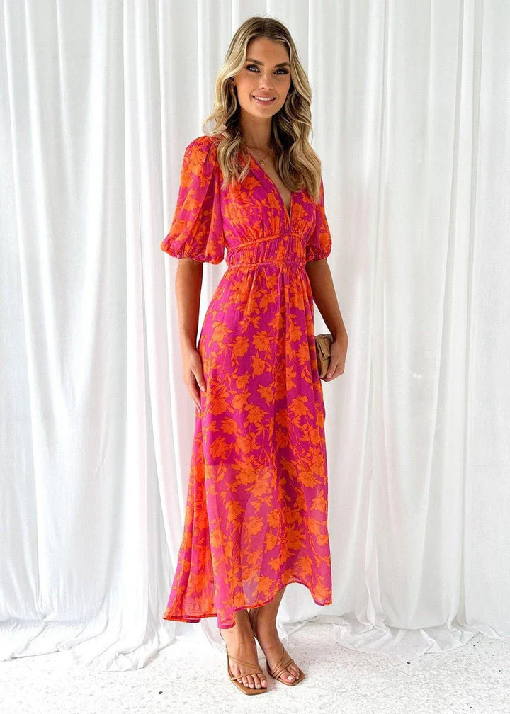 Floral midi dress featuring statement puff sleeves and flattering V-neckline in bright pink and orange tones