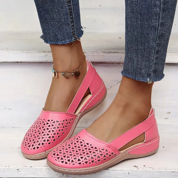 Detail of women's flats showing geometric perforations and structured material with smooth finish