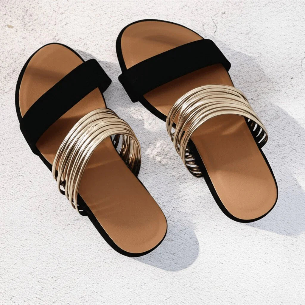 Full view of women's orthopedic sandals featuring black fabric straps, metallic toe detail, and contoured arch support footbed