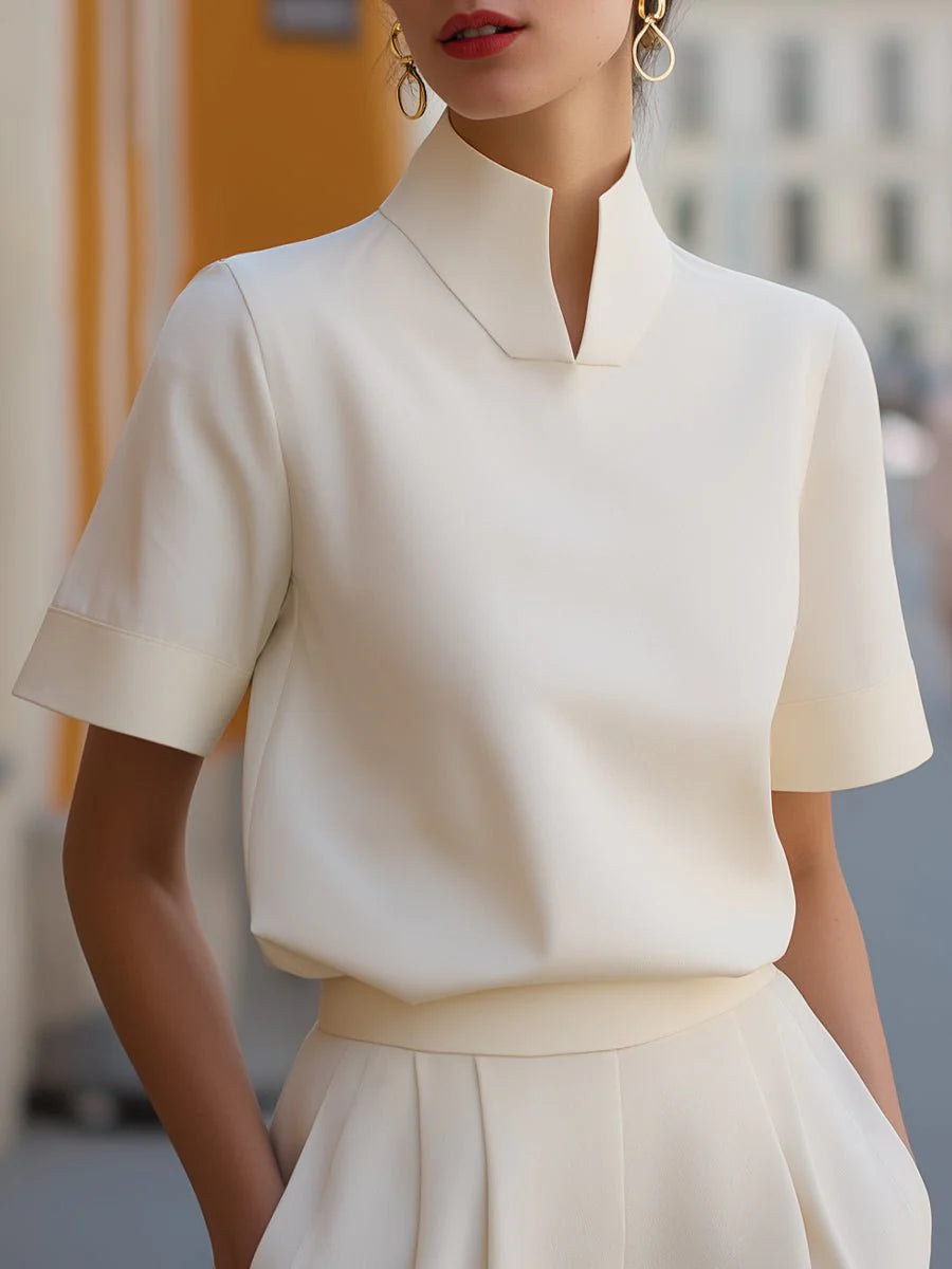 Women's stand collar short sleeve blouse in cream with architectural split neckline and tailored fit