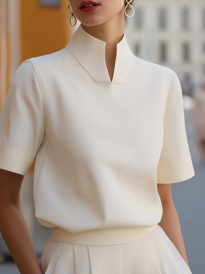 Side view of women's short sleeve blouse with stand collar and minimalist design