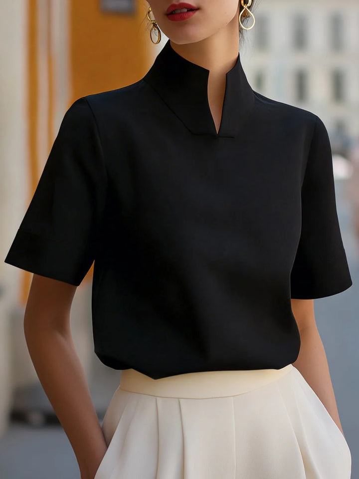 Women's structured blouse in cream paired with pleated skirt for smart-casual styling