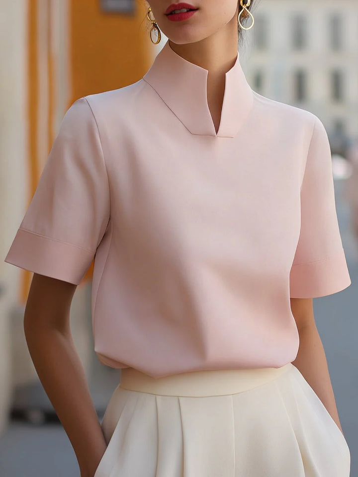 Detail of short sleeve construction on women's structured stand collar blouse