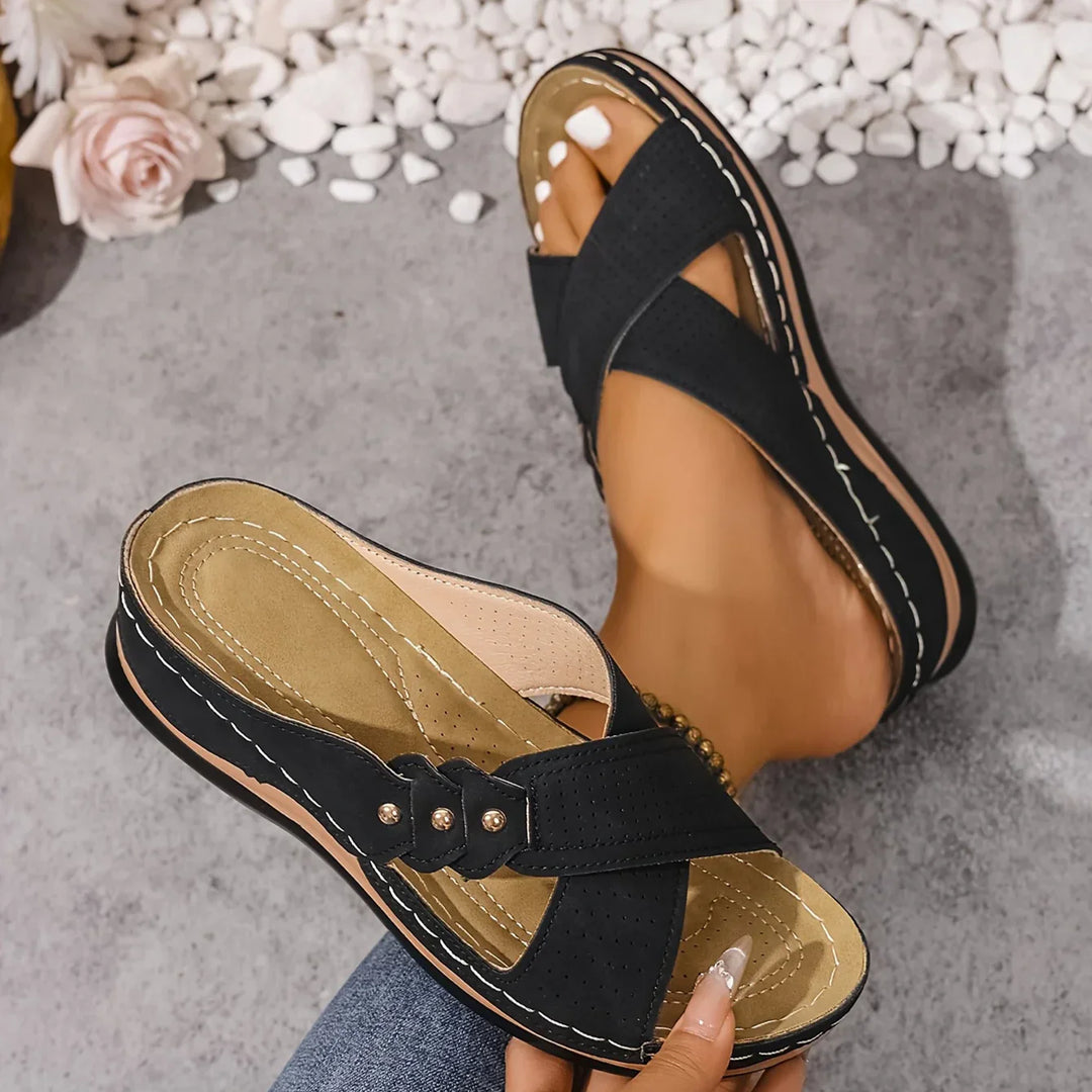 Close-up of perforated upper detailing on women's navy blue crossover strap wedge sandals