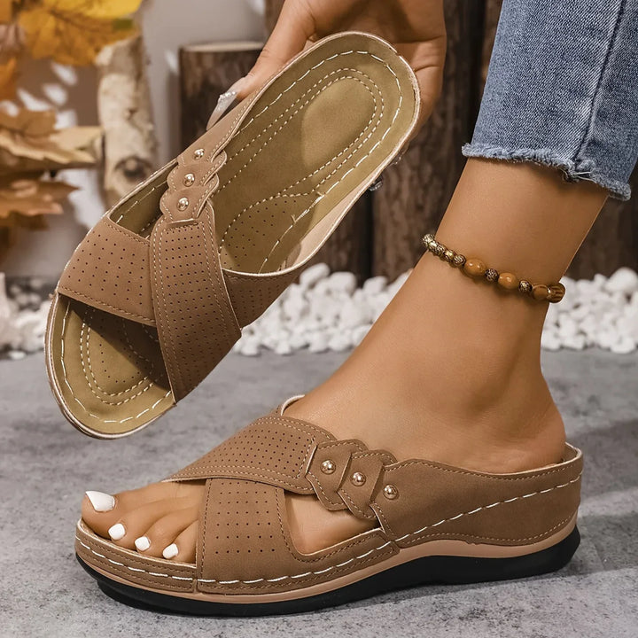 Women's navy blue wedge sandals with contrast tan footbed and decorative stud accents