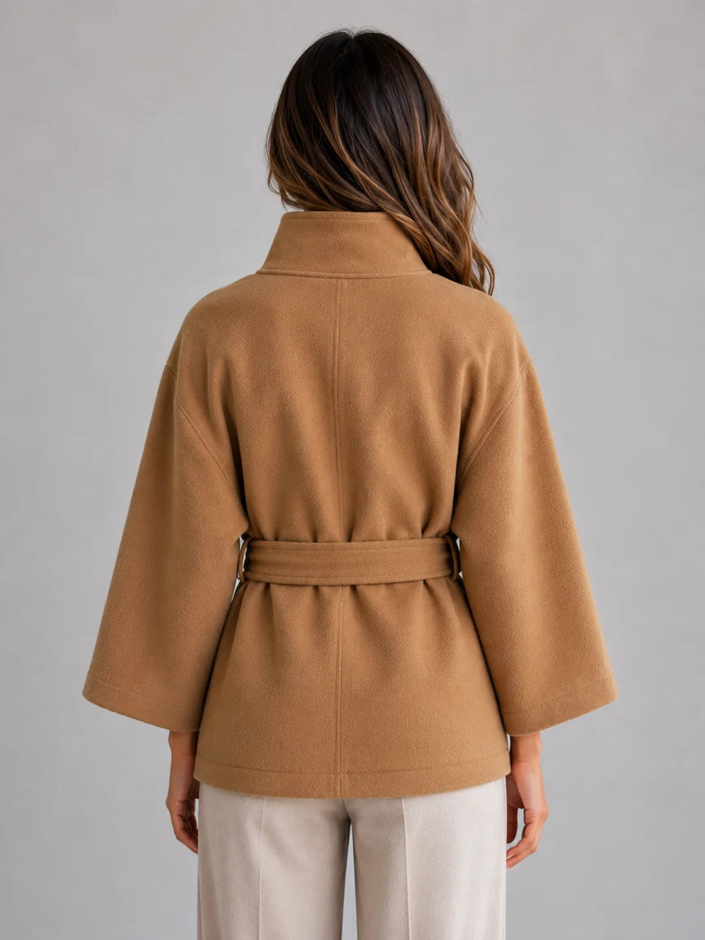 Front view of belted cape jacket showing structured stand collar and button-front fastening detail