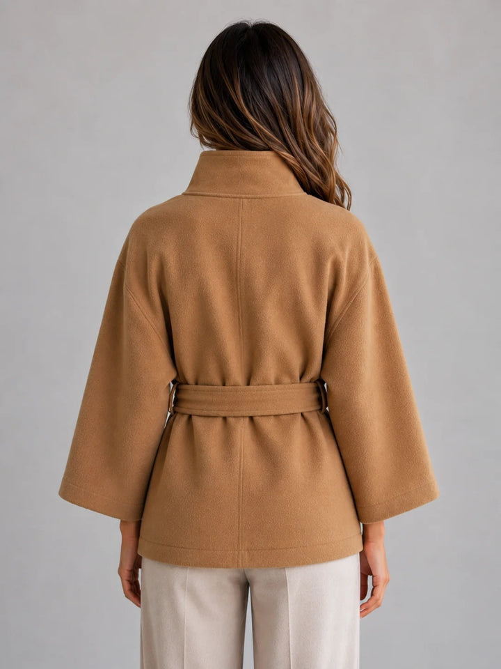 Front view of belted cape jacket showing structured stand collar and button-front fastening detail