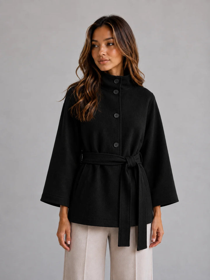 Full-length view of belted cape coat styled over tailored trousers for smart-casual look